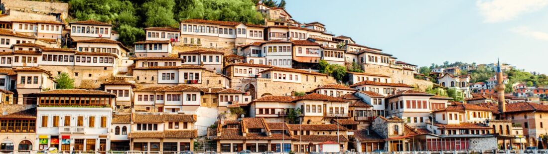 picture of albanian village with beautiful old buildings climbing a hill